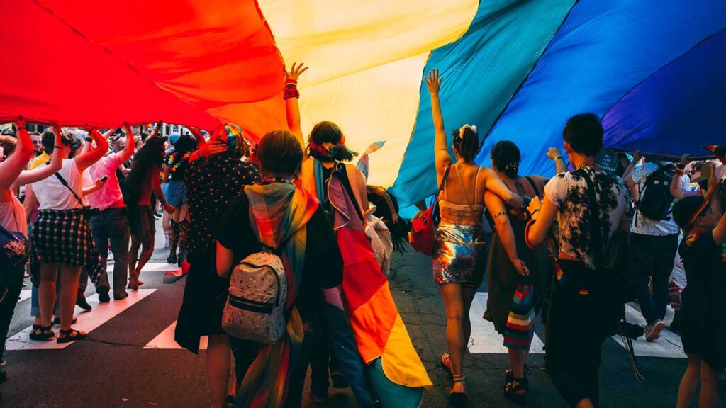 dance party under rainbow flag tent