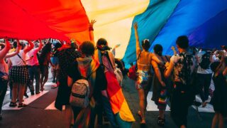 dance party under rainbow flag tent