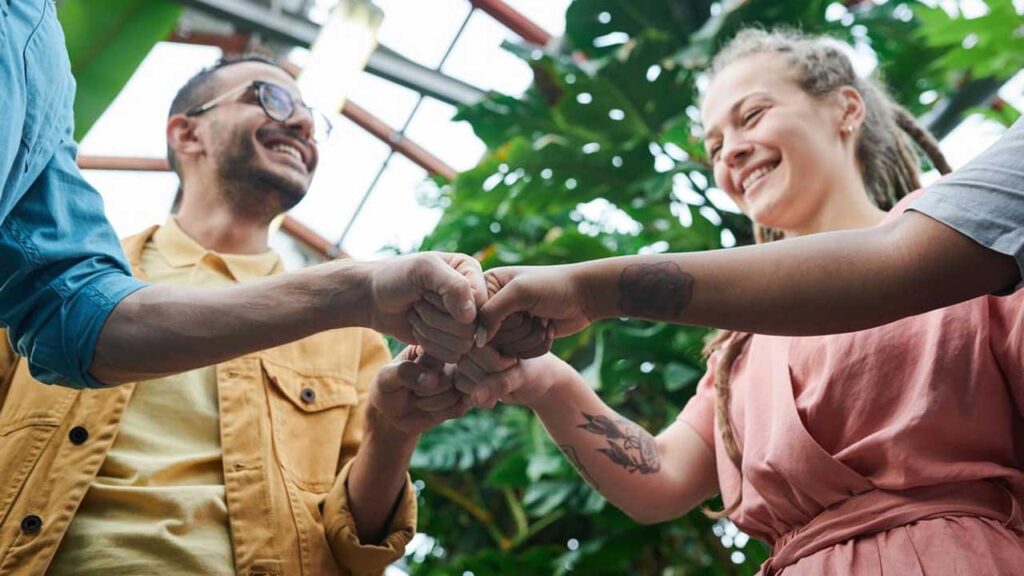 4 way fist bump between smiling people