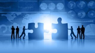 people pushing giant puzzle pieces together