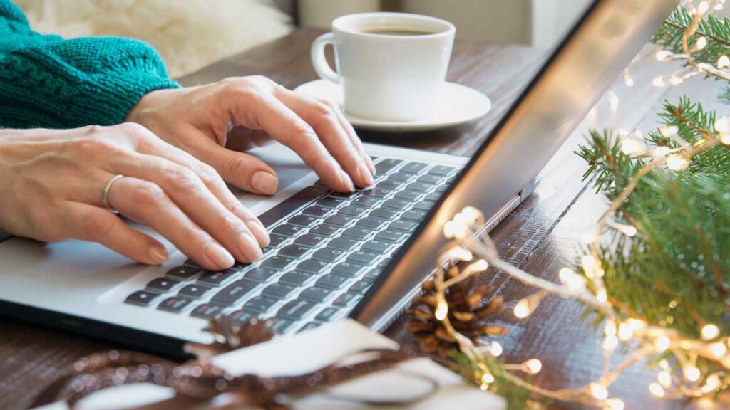 person at laptop keyboard during christmas