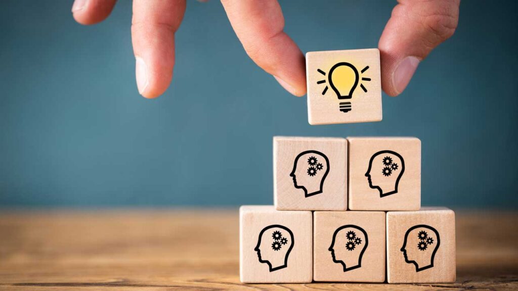 heads on blocks with light bulb on top block