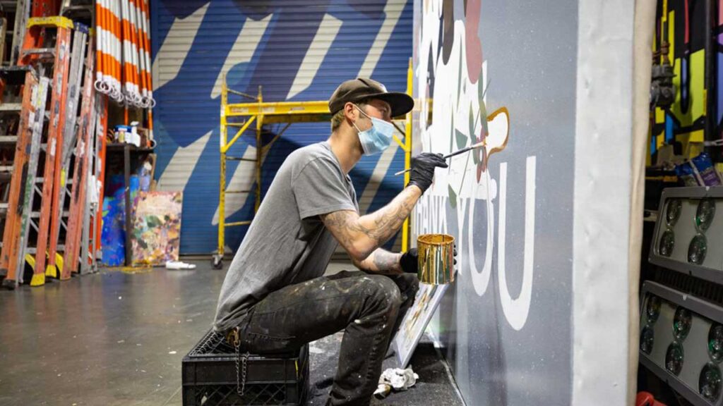 person painting mural advert