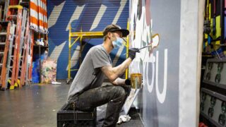 person painting mural advert