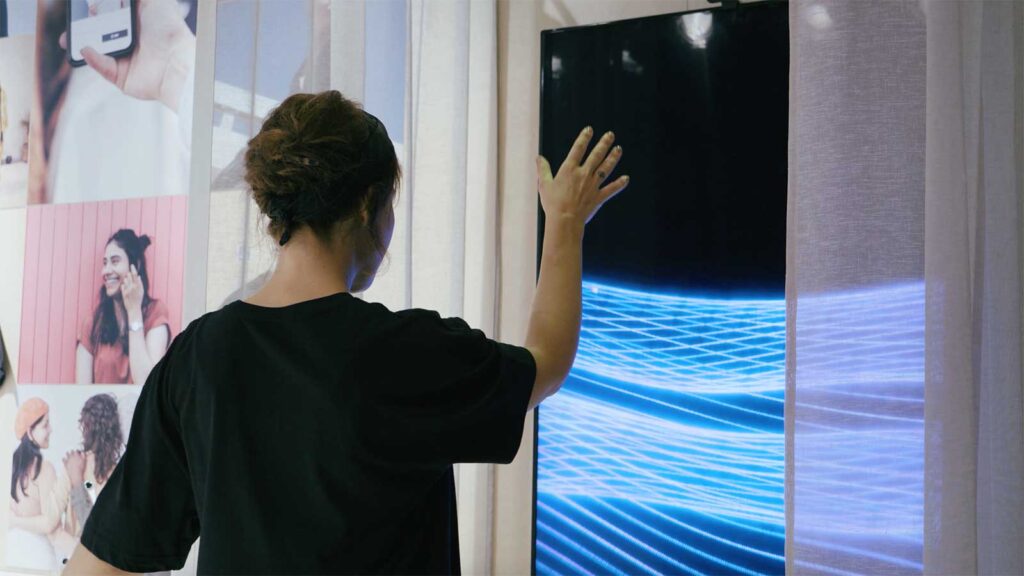 person with digital screen through window