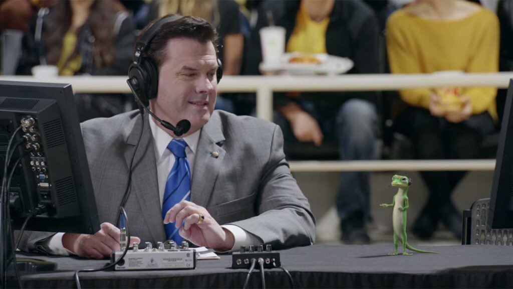 sports broadcaster with geico lizard