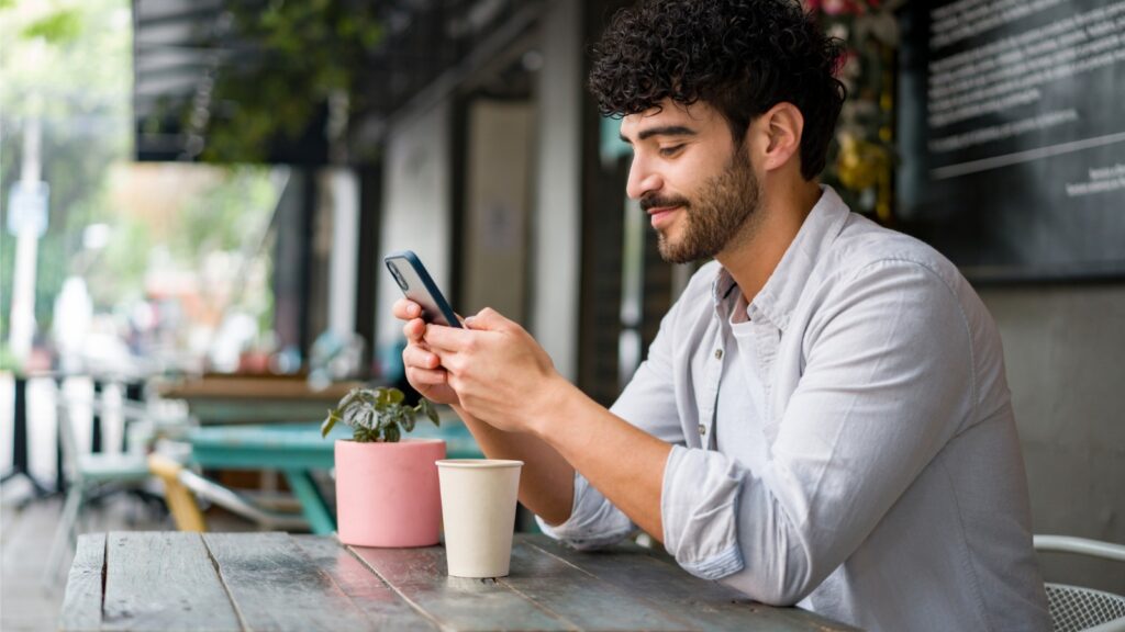 man at restaurant looking at phone