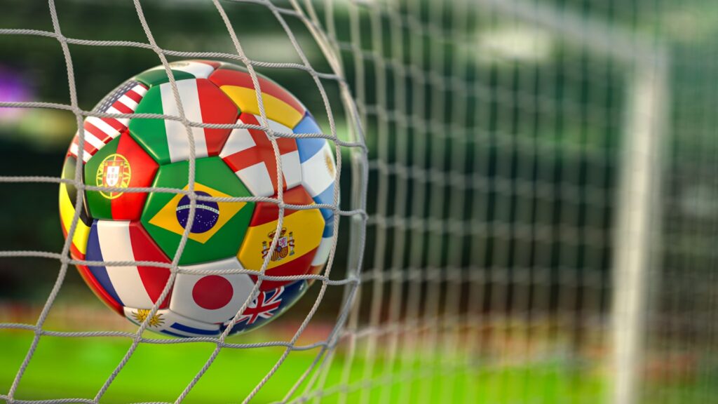 Football ball with flags of world countries in the net of goal of football stadium. World cup championship 2022.