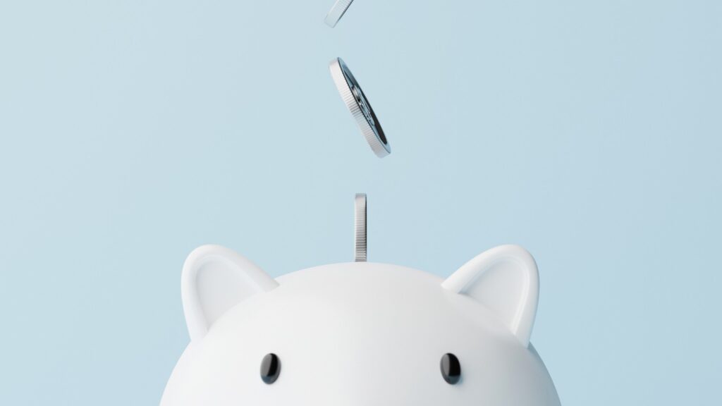 Save money and investment concept. Closeup piggy bank and silver coins falling.