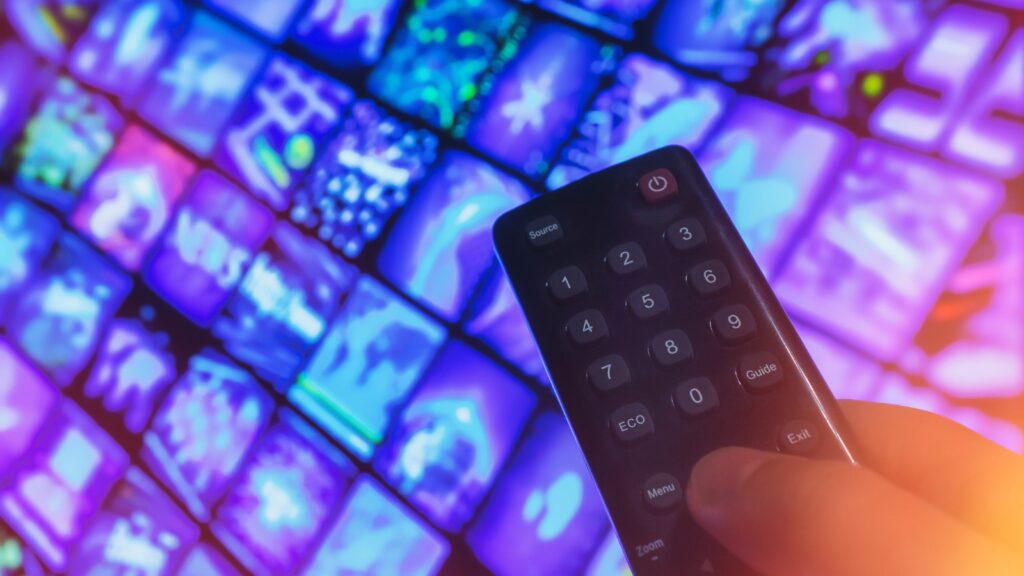 video-on-demand-screen-with-remote-control-in-hand-picture-id1291170652